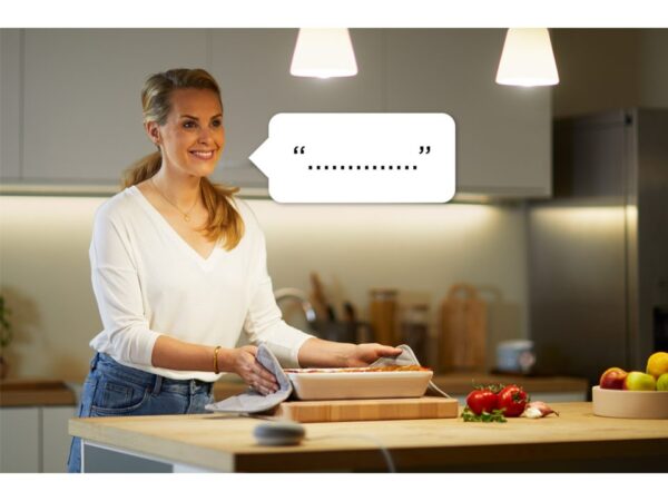 žena pracující v kuchyni ovládá hlasem asistenta chytré domácnosti