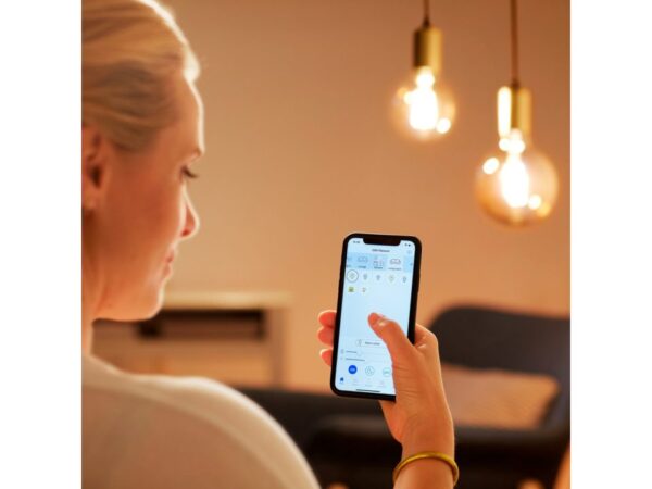 pohled do mobilu ženy nastavující osvětlení