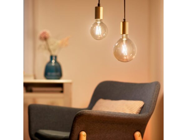 teple svítící žárovky WiZ bez stínidel s modrrým křeslem v pozadí