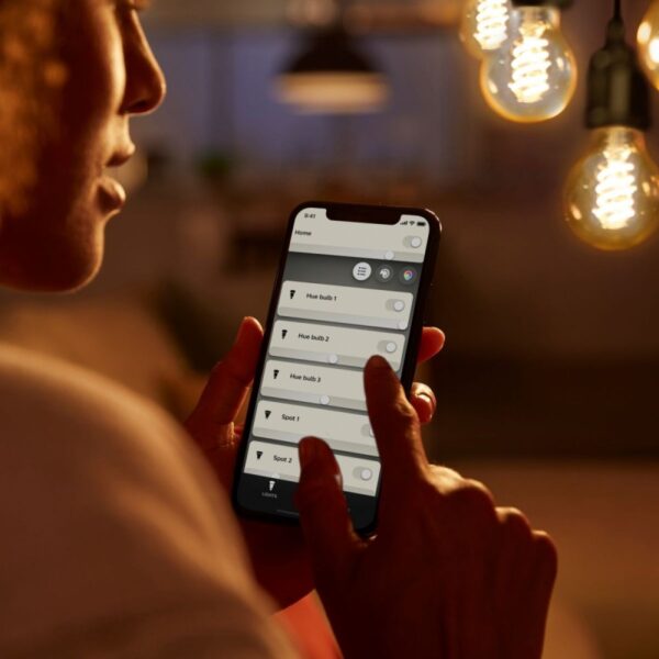 žena ovládá žárovky Philips Hue pomocí mobilní plikace