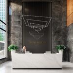 lustr z LED profilů zavěšených šikmě v prostoru nad recepcí